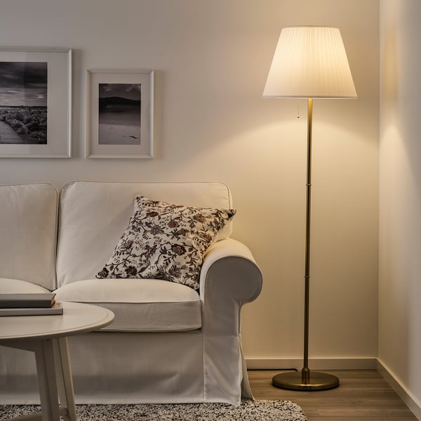 Cosy living room with KRYSSMAST lamp beside sofa.