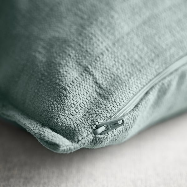 Light blue-grey cushion cover, zip detail, textured fabric.