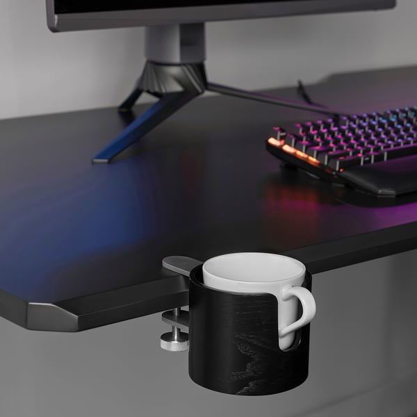 Clamp-on mug holder attached to modern desk, holding white mug.