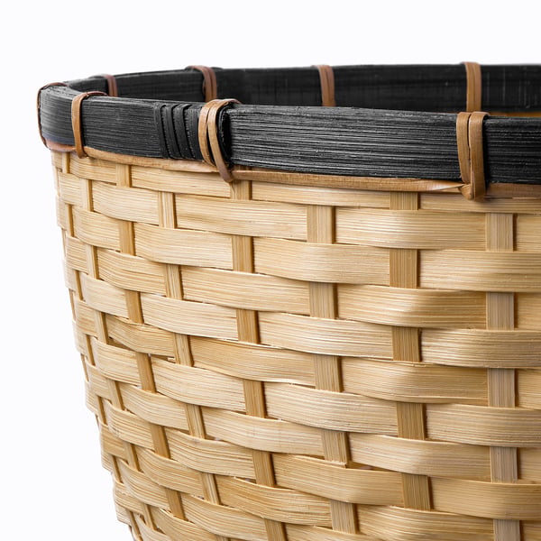 Handwoven bamboo basket with intricate braiding and sturdy handle detail. Displaying fine craftsmanship and natural beauty.
