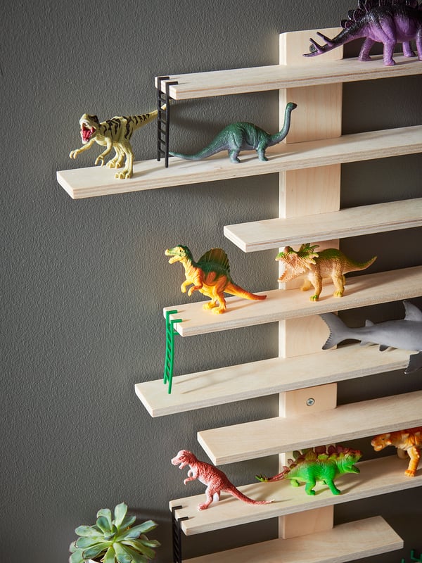 White wall shelf with adjustable wooden levels colourful dinosaur toys; modern, playful design.