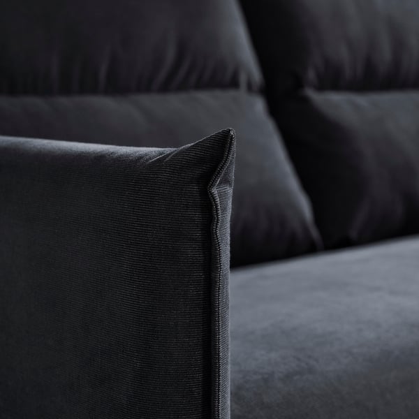 Black sofa close-up. Soft fabric, neat stitching, comfortable cushions. Modern and elegant design.