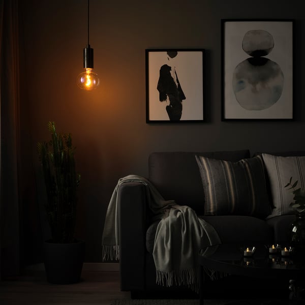 Cosy room with dim light, sofa, and art.