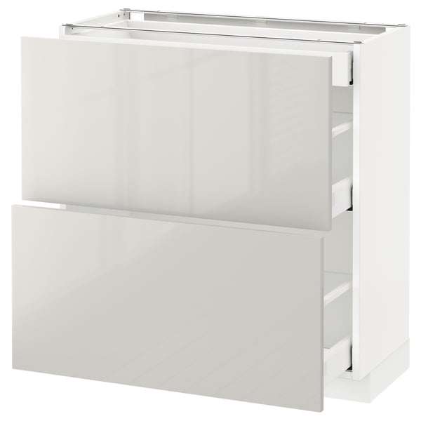 Displays a white, modern kitchen cabinet from the ikea METOD series, featuring sleek, high-gloss surfaces and multiple drawers.