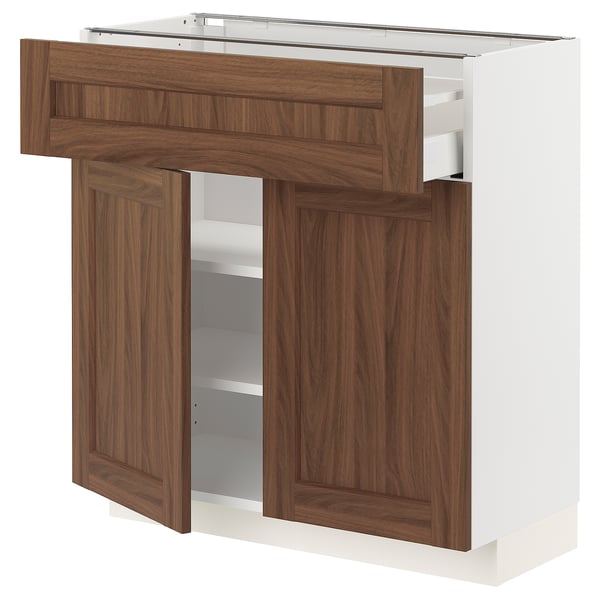 A METOD kitchen unit with walnut wood-effect doors and a white frame. It includes drawers and shelves for storage.