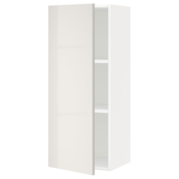 A white METOD kitchen wall cabinet with a high gloss finish, rectangular shape, and single door. It one adjustable shelf inside.