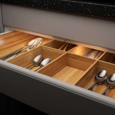 Wooden drawer organiser with built-in led, lighting up kitchen utensils in compartments.