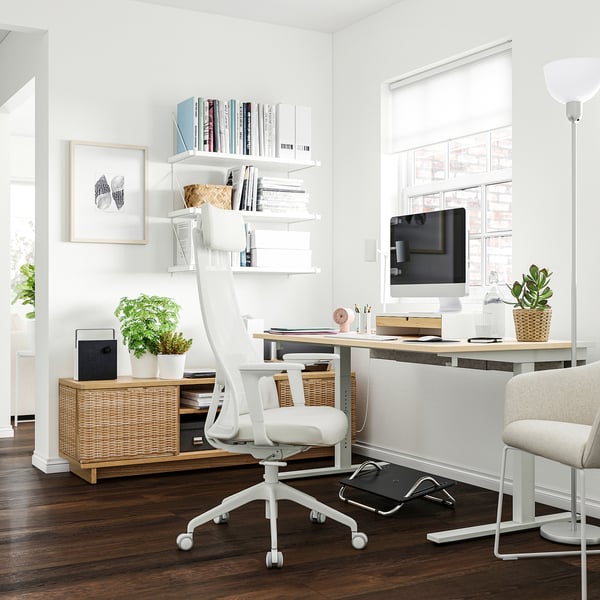 Modern home office featuring MITTZON desk with white chair, computer, plants, and books.