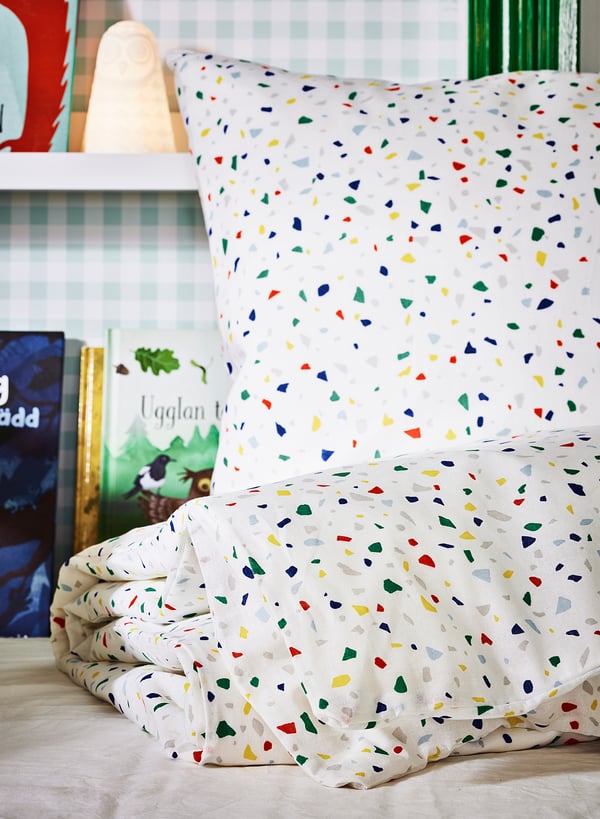 Brightly coloured multicoloured square duvet cover and pillow set on bed.