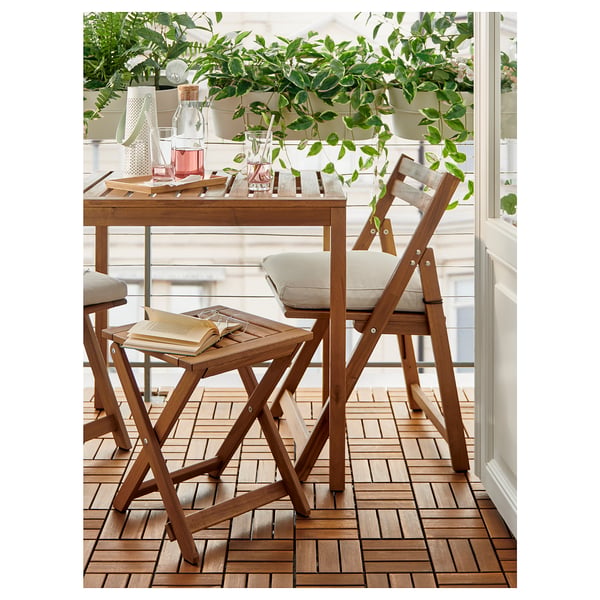 Wooden balcony set with light cushions, plants, and books.