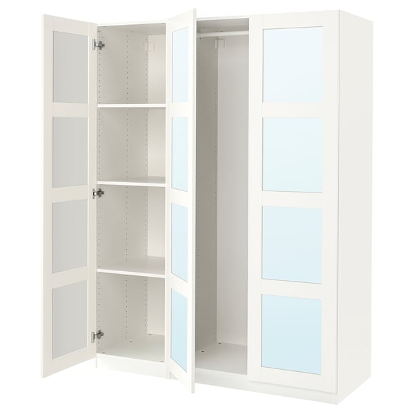 White ikea PAX wardrobe with mirrored doors open, revealing adjustable shelves.