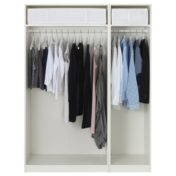 Closed white wardrobe with hangers, neatly arranged shirts and clothes.