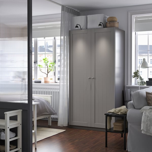 Modern living room with tall grey PAX wardrobe, enhancing space and design.