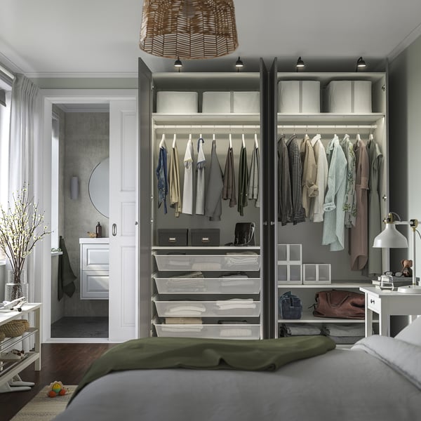 Modern bedroom with built-in wardrobe PAX showing organised clothes, shelves, and lights.