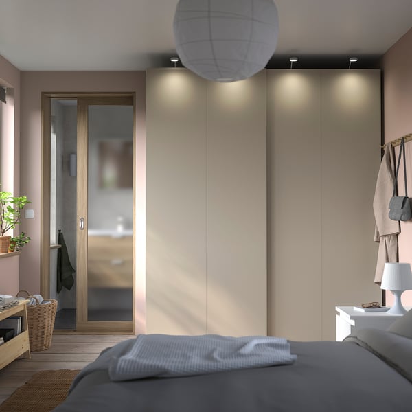 Modern bedroom with grey bed, large built-in closet with sliding doors, and a tall lamp.