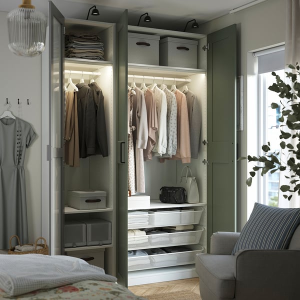 Open wardrobe with clothes, accessories, and storage. Mirrored doors expand space. Integrated lighting illuminates contents.