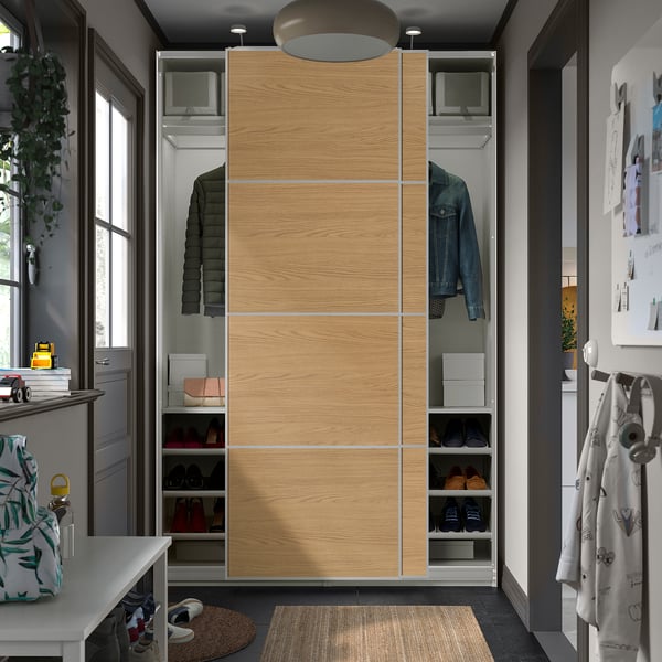 Modern wardrobe with sliding oak doors, housing clothes and shoes in an organised space.