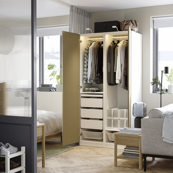 A modern bedroom with an open wardrobe displaying clothing and storage solutions.