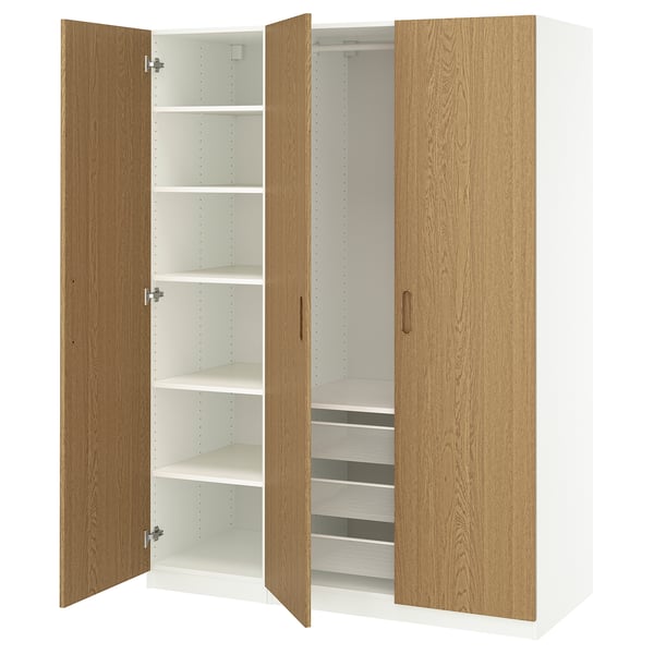 An open wooden PAX wardrobe. It has light oak doors and white interiors with shelves and mesh drawers.
