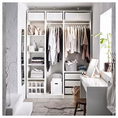 Neat closet with PAX system, shelves, hanging space, and bins. Neutral clothes and plants.