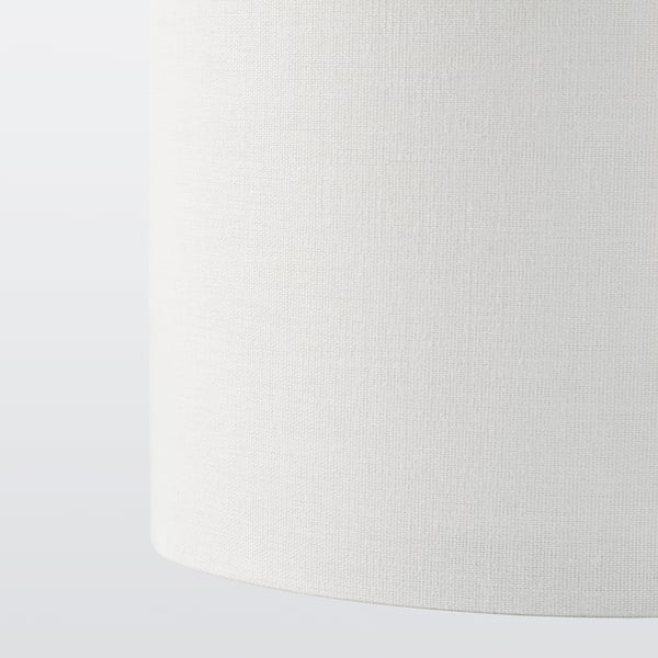Close-up of textured white lamp shade; subtly patterned, diffusing soft light.