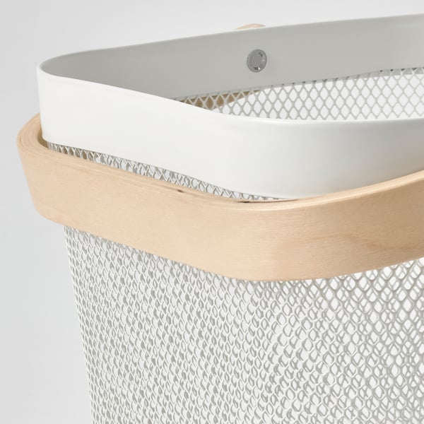 Detail of stylish storage basket with ventilation holes, light wood handle.