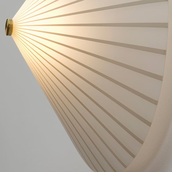 A modern wall lamp with a striped, opaque glass shade casting soft, diffused light. Gold-colored metal fixture.