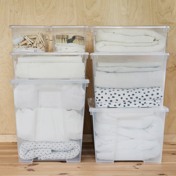 Four stacked SAMLA boxes. Top boxes hold clothespins, brushes. Bottom boxes store towels, linens.