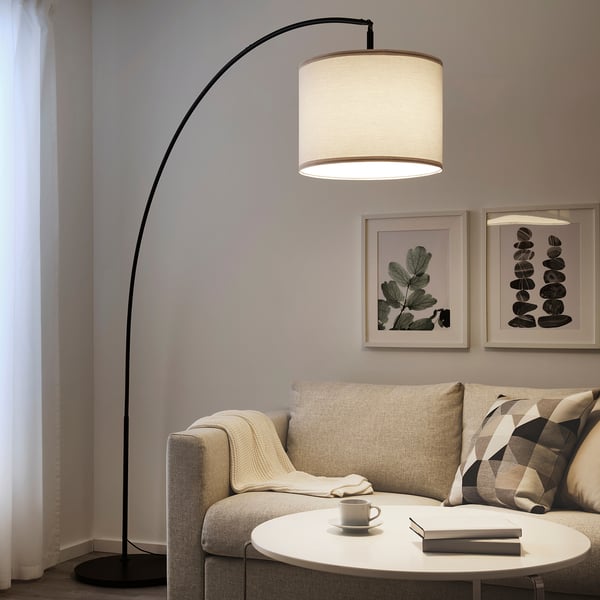 Modern living room with SKAFTET floor lamp, beige sofa, coffee table, and wall art.