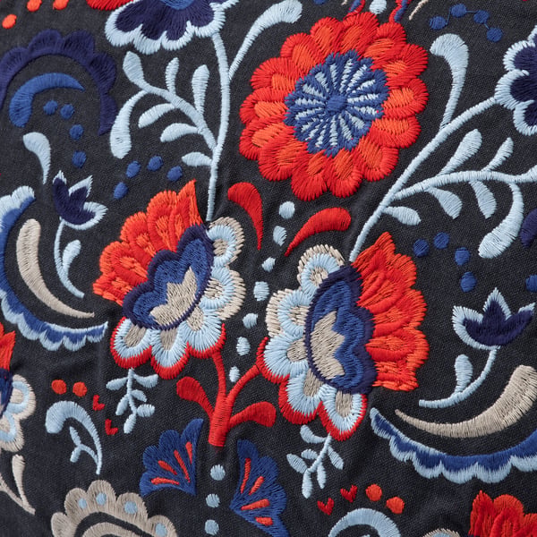 Elaborate embroidered flowers on black fabric, showcasing intricate craftsmanship.