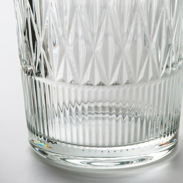 Elegant crystal glass vase with intricate cut patterns, reflecting light and casting rainbow hues. Luxurious and detailed craftsmanship.