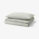 Two green and white striped pillows, neatly folded rectangular duvet cover set with classic stripe design.