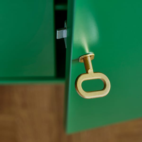 Golden handle on green cabinet, showing high quality finish and design.