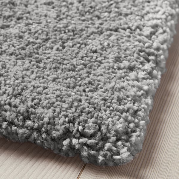 Light grey plush rug on wood floor, soft & cosy for bedrooms or living rooms.