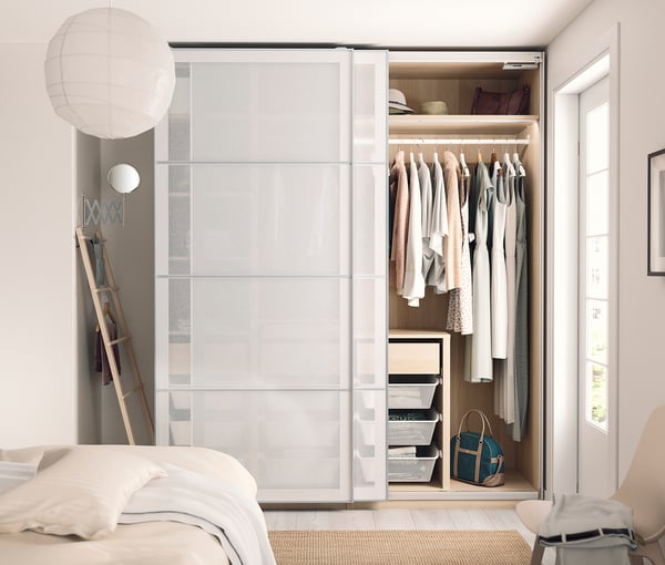 Modern bedroom with SVARTISDAL wardrobe, soft lighting, and minimalist decor.