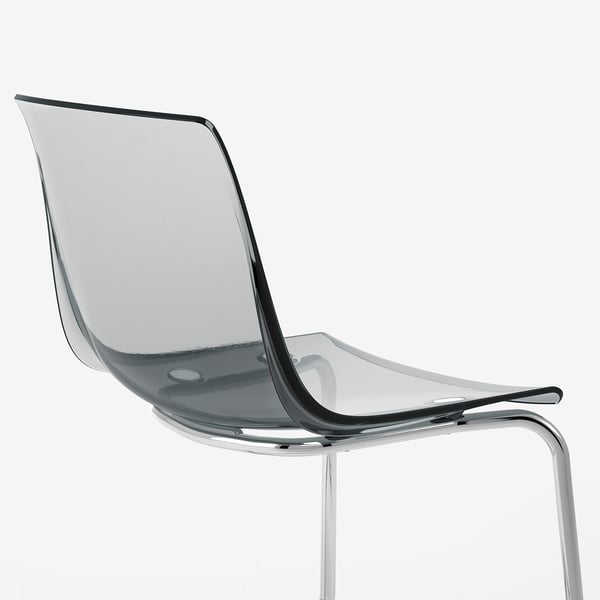 Clear, modern chair with sleek, curved design. Chrome legs and transparent seat. Floating, contemporary style.