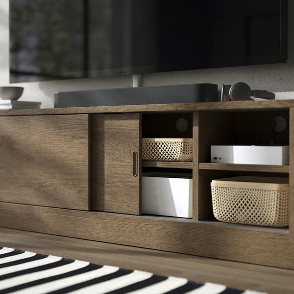Wooden tv stand with sliding doors, showcasing cable management and adjustable shelves.