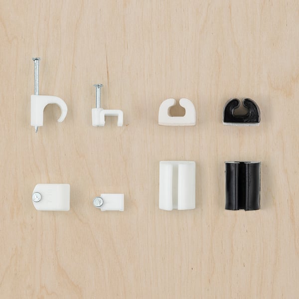 Eight cable management clips in white and black colours, made of plastic, displayed on wood. Includes nail, self-adhesive, and boxed clips.