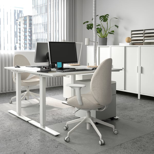 Minimalist office with TROTTEN desk, ergonomic chairs, dual monitors, and plant.