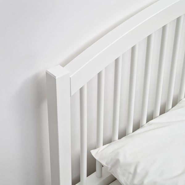 A well-crafted white wooden headboard with vertical slats, showing sturdy and clean design, part of a minimalist bed frame.
