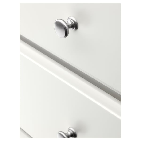 Close-up of white chest of drawers with metallic knobs, showcasing smooth, soft-closing drawers and polished edges.