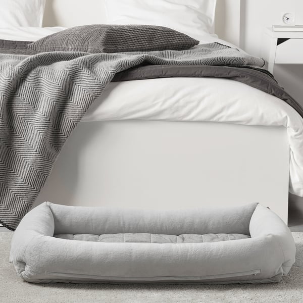 A cosy dog bed, UTSÅDD, a bolstered edge for support and relaxation. The soft, machine-washable cover is perfect for indoor pets.
