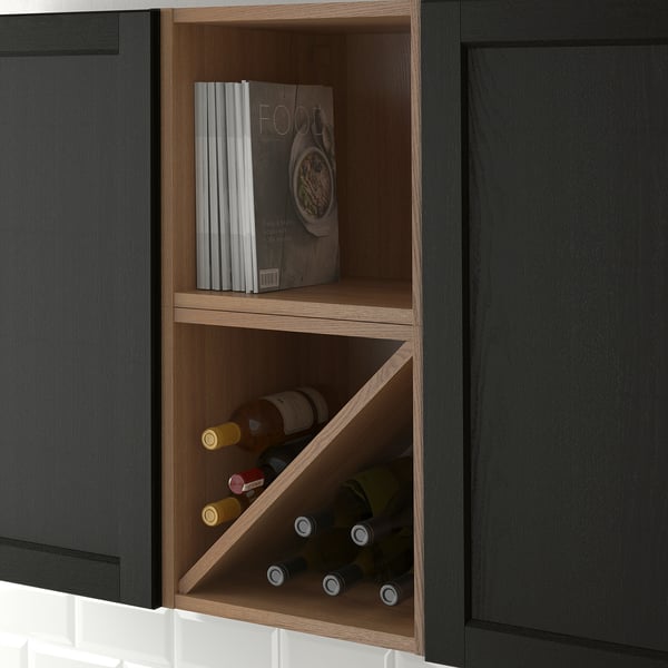 Open kitchen cabinet with wine bottles and cookbooks, part of VADHOLMA storage solutions.
