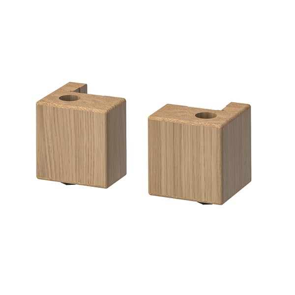 Two light brown, rectangular wooden blocks with cylindrical holes are displayed side by side.