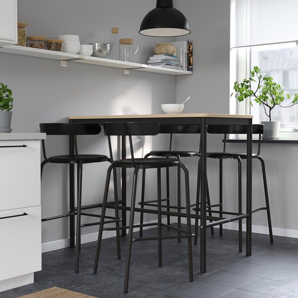 Modern kitchen with black YNGVAR stools. Rounded, beech veneer, durable, complements decor, hangs for easy cleaning.