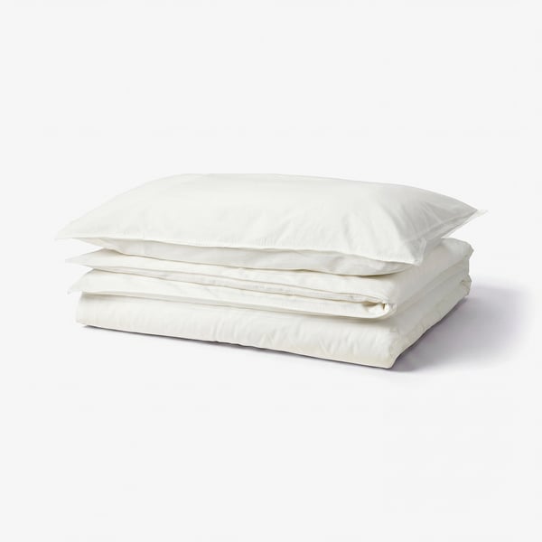 A stack of white ÄNGSLILJA cotton duvet covers, neatly folded.