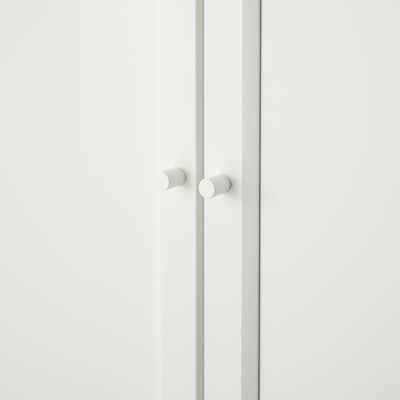 White cabinet doors with round knobs; minimalist design.