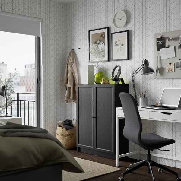 Modern bedroom with dark grey BILLY bookcase, olive-green bed, desk, and natural light.