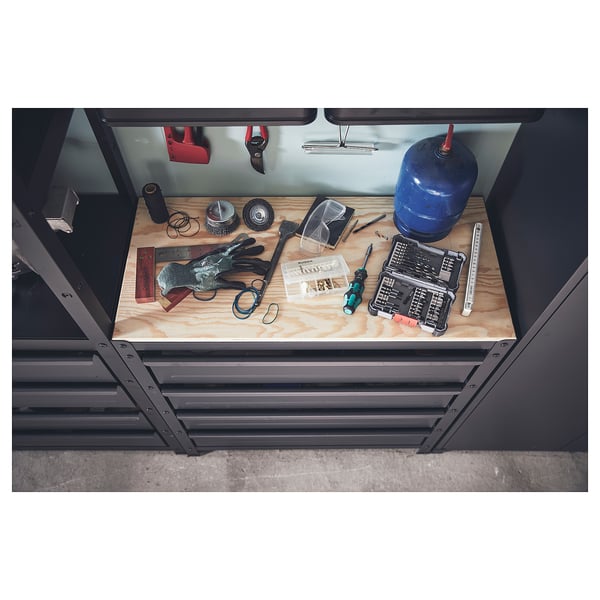 A BROR workbench with drawers, featuring a grey frame and a wooden top. It holds various tools and items, keeping them organised.