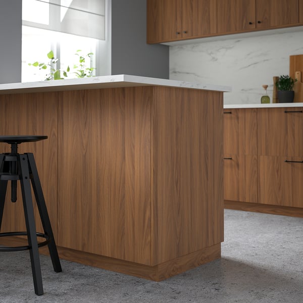 FÖRBÄTTRA walnut side panel; sleek, modern kitchen design. Medium wood tone, fits perfectly below marble countertop, and extends beside black stool.